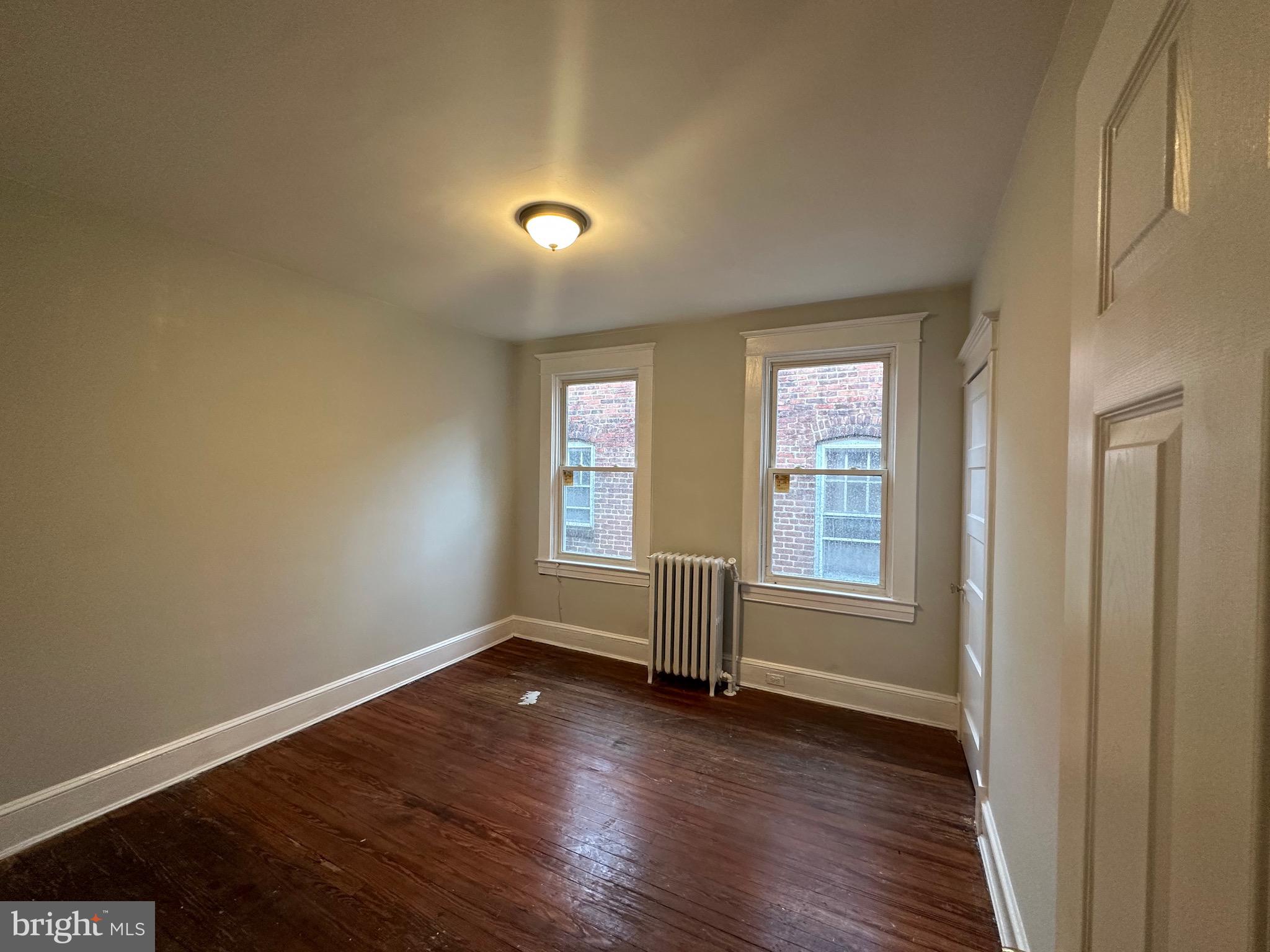 4227 Euclid Avenue, Unit B Baltimore, MD 21229 - Photo 48 of 87 an empty room with wooden floor and windows