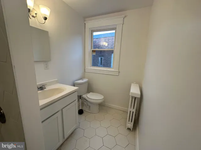 an empty room with a chandelier fan and wooden floor