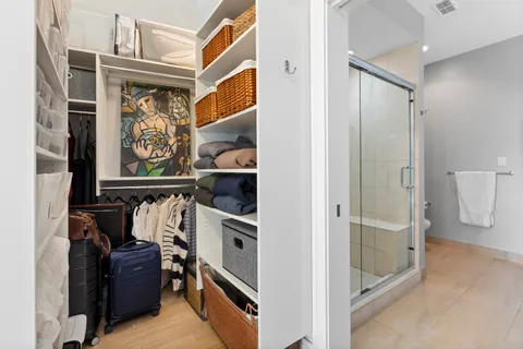 a view of walk in closet with clothes and shoes