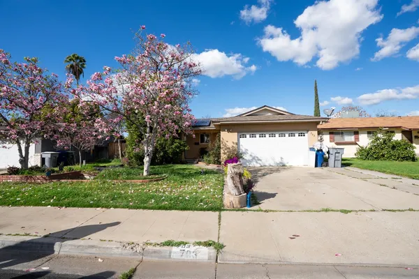 a front view of a house with a garden and mountain view
