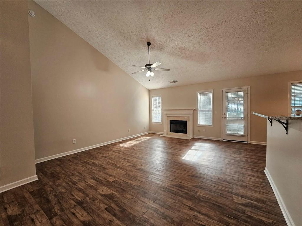 190 Berkley Drive Villa Rica, GA 30180 - Photo 12 of 38 an empty room with wooden floor fireplace and windows