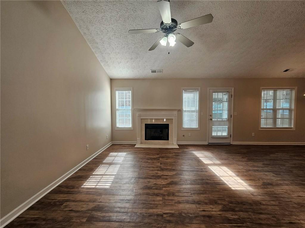 190 Berkley Drive Villa Rica, GA 30180 - Photo 13 of 38 an empty room with wooden floor fireplace and windows