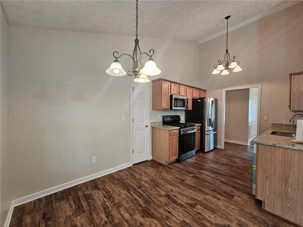 190 Berkley Drive Villa Rica, GA 30180 - Photo 16 of 38 a kitchen with kitchen island granite countertop stainless steel appliances a stove top oven a sink and dishwasher a refrigerator with wooden floor