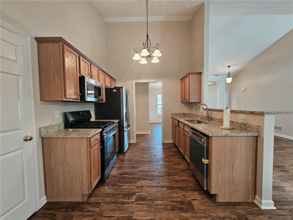 190 Berkley Drive Villa Rica, GA 30180 - Photo 17 of 38 a large kitchen with stainless steel appliances granite countertop a stove a sink dishwasher a refrigerator and a oven with wooden floor