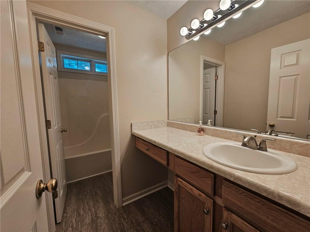 190 Berkley Drive Villa Rica, GA 30180 - Photo 30 of 38 a bathroom with a granite countertop sink a light fixture and a mirror