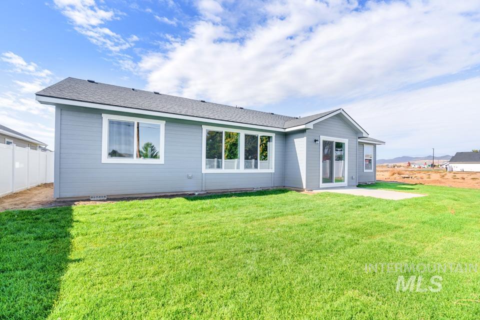 1340 Dawn Street Weiser, ID 83672 - Photo 28 of 32 Rear view of house featuring roof with shingles, a lawn, and a patio
