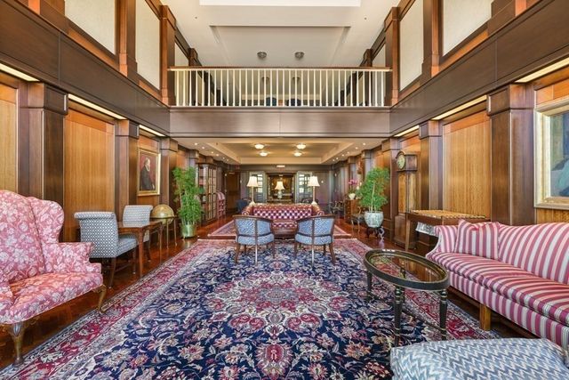 a living room with furniture a chandelier and a large window