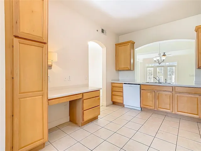a view of an empty room with wooden floor and a chandelier