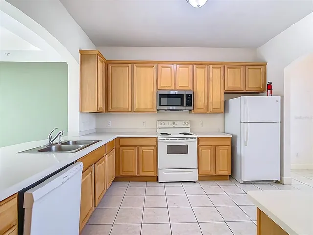 a white toilet sitting next to a white wall
