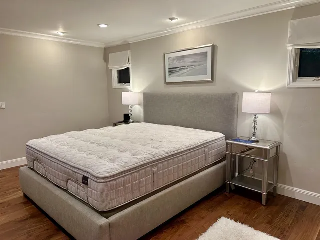 a bedroom with a bed and wooden floor