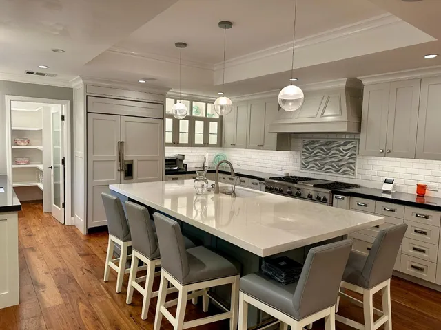 a kitchen with a dining table chairs cabinets and stainless steel appliances