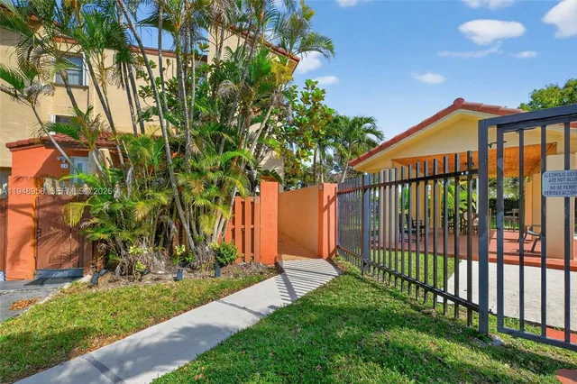 a view of a house with a small yard and a large tree