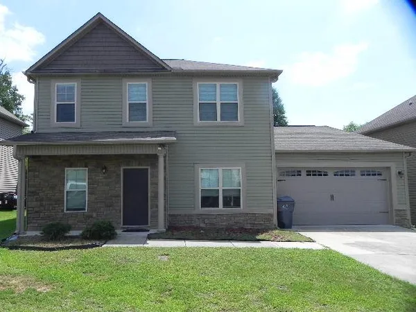 a front view of a house with a yard and garage