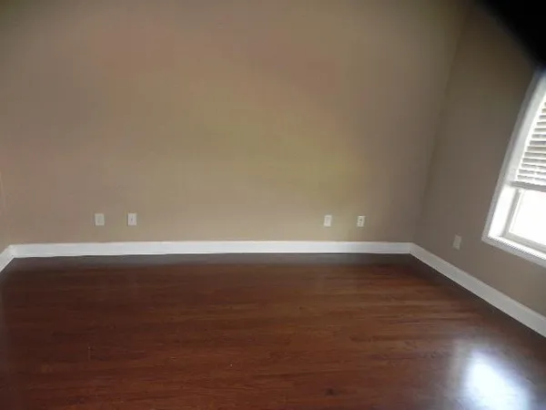 a view of a room with wooden floor and window