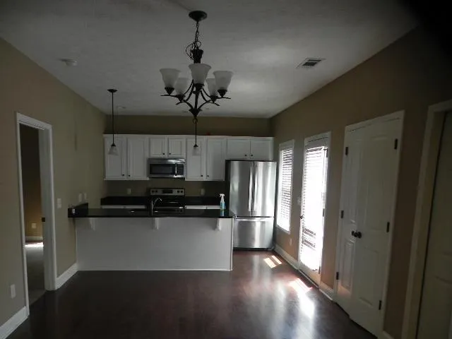 a kitchen with stainless steel appliances a refrigerator a stove a microwave and cabinets