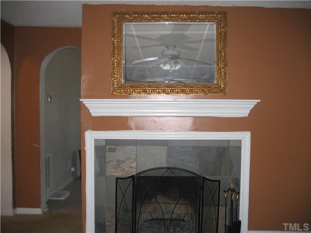 2664 Shotwell Road Clayton, NC 27520 - Photo 6 of 11 Large Living Room with 2 ceiling fans, woodburning fireplace with slate surround and hearth. Mirror, fireplace screen and tools convey.
