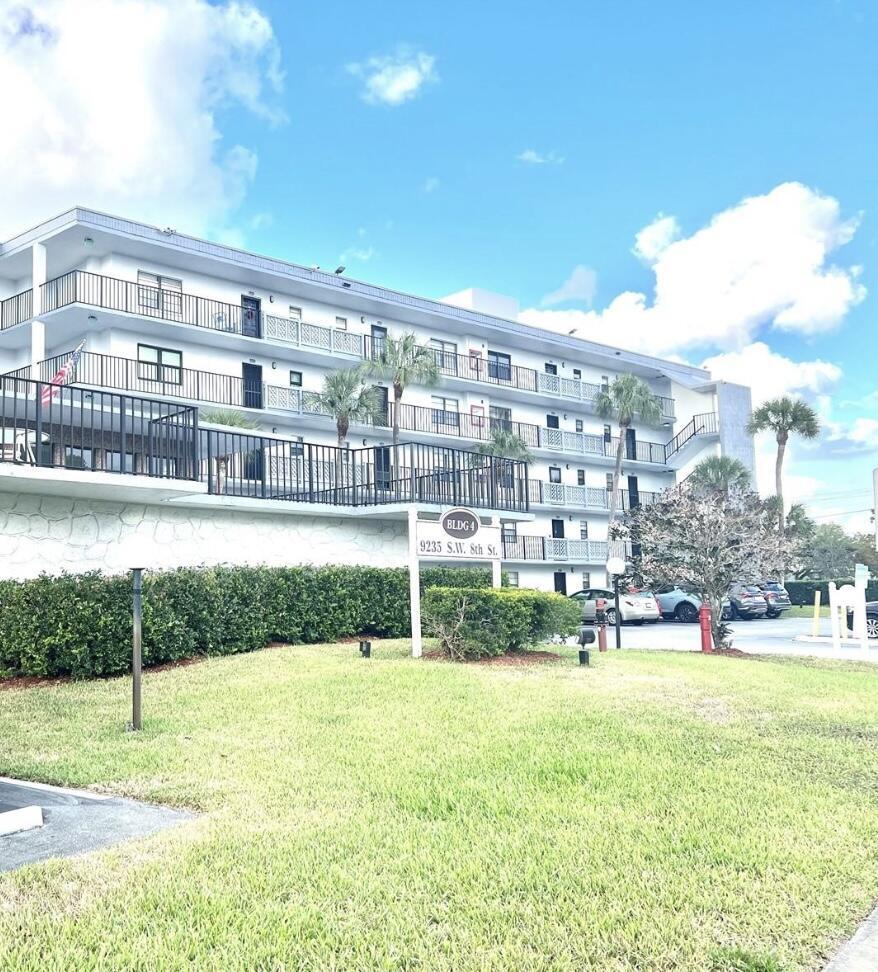 9235 Southwest 8th Street, Unit 507 Boca Raton, FL 33428 - Photo 13 of 16 a view of a building with a yard