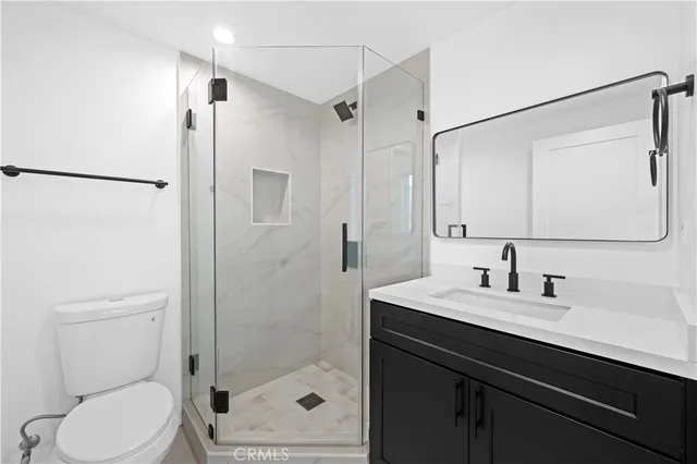 a bathroom with a sink toilet a mirror and shower