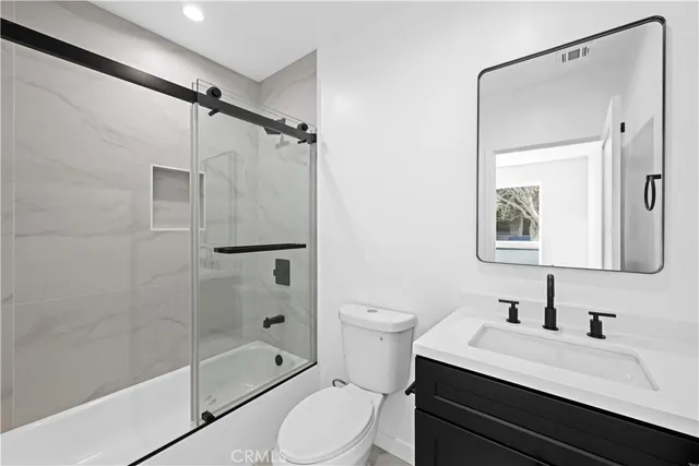 a bathroom with a sink toilet a mirror and shower