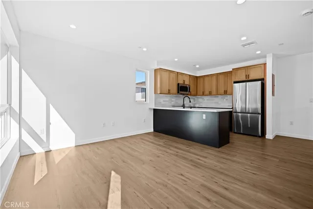 a kitchen with stainless steel appliances a refrigerator and a stove top oven