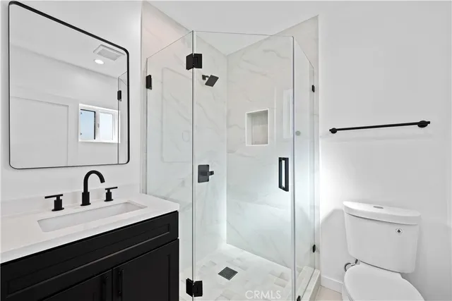 a bathroom with a shower sink mirror and toilet