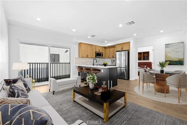 a living room with furniture kitchen view and a large window