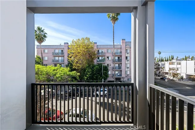 a view of a balcony with floor to ceiling window and wooden fence