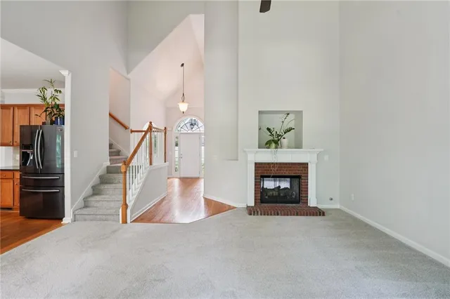 a view of an empty room with fireplace and stairs