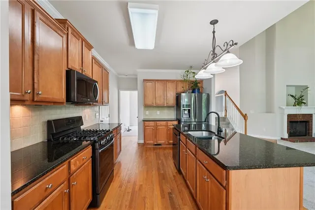 a kitchen with granite countertop a sink a counter space appliances and cabinets