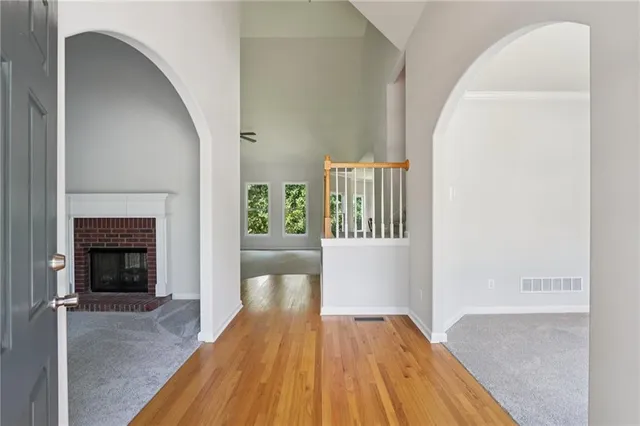 a view of a livingroom with wooden floor and a fireplace