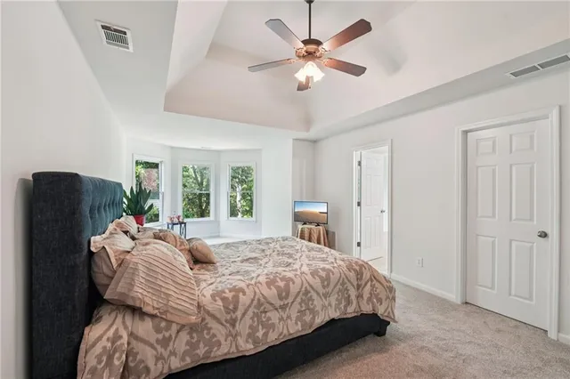 a spacious bedroom with a bed and a chandelier