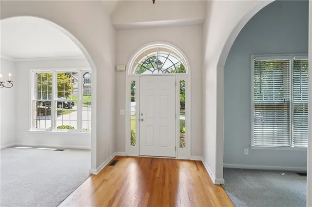 an empty room with wooden floor a glass door and a window