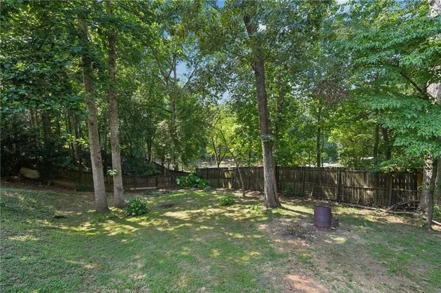 a backyard of a house with lots of plants and tree