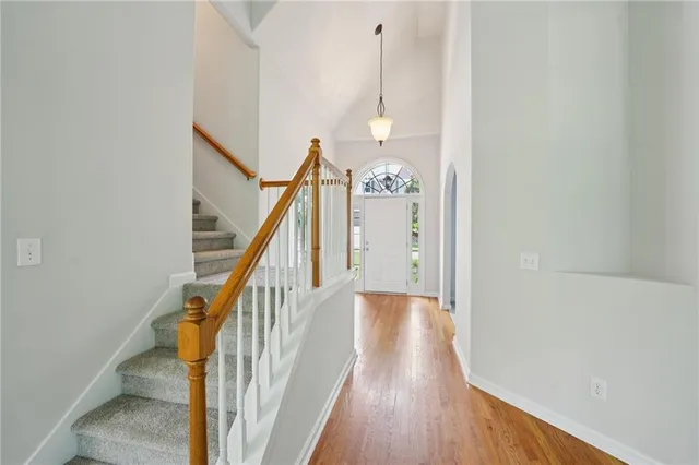 a view of a hallway with wooden floor and staircase
