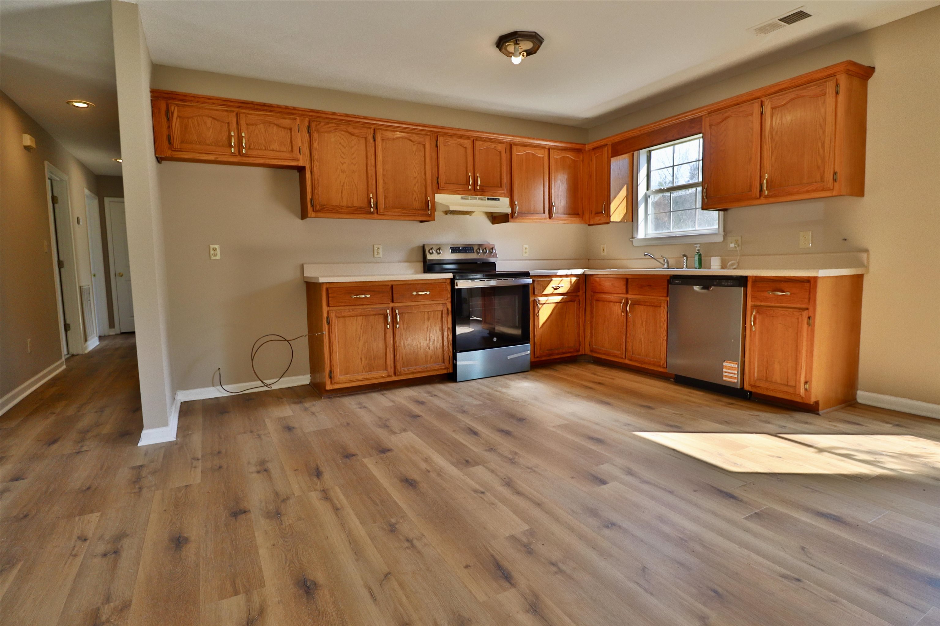 1714 Conner Whitefield Road Ripley, TN 38063 - Photo 3 of 37 a kitchen with granite countertop wooden floors stainless steel appliances a sink and a window
