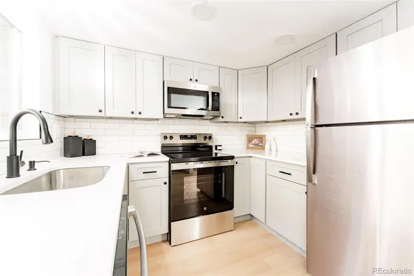 a kitchen with stainless steel appliances a refrigerator sink and white cabinets