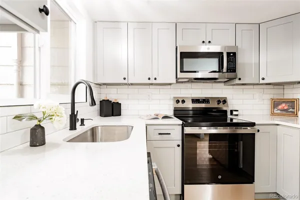 a kitchen with stainless steel appliances granite countertop a sink a stove and a microwave