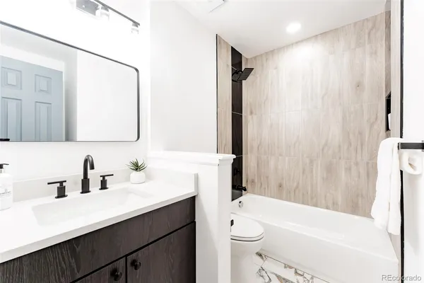 a bathroom with a sink a toilet a mirror and shower