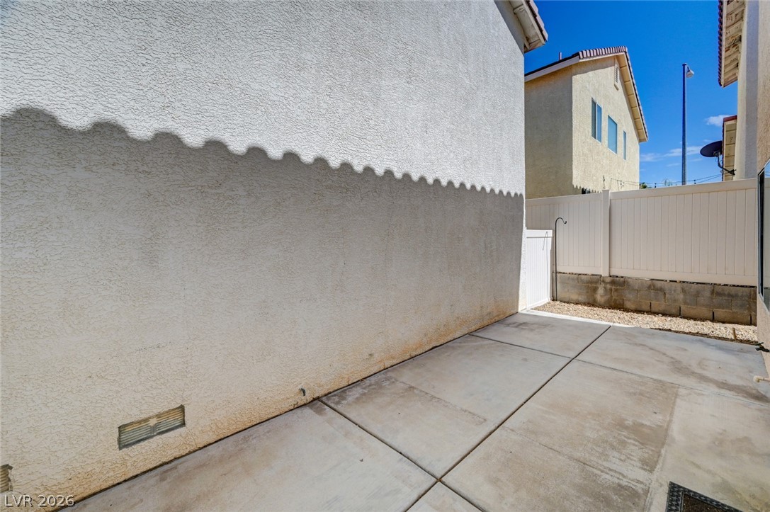 7259 Cestrum Road Las Vegas, NV 89113 - Photo 26 of 35 A well-maintained side yard with a concrete path, offering a private outdoor space.