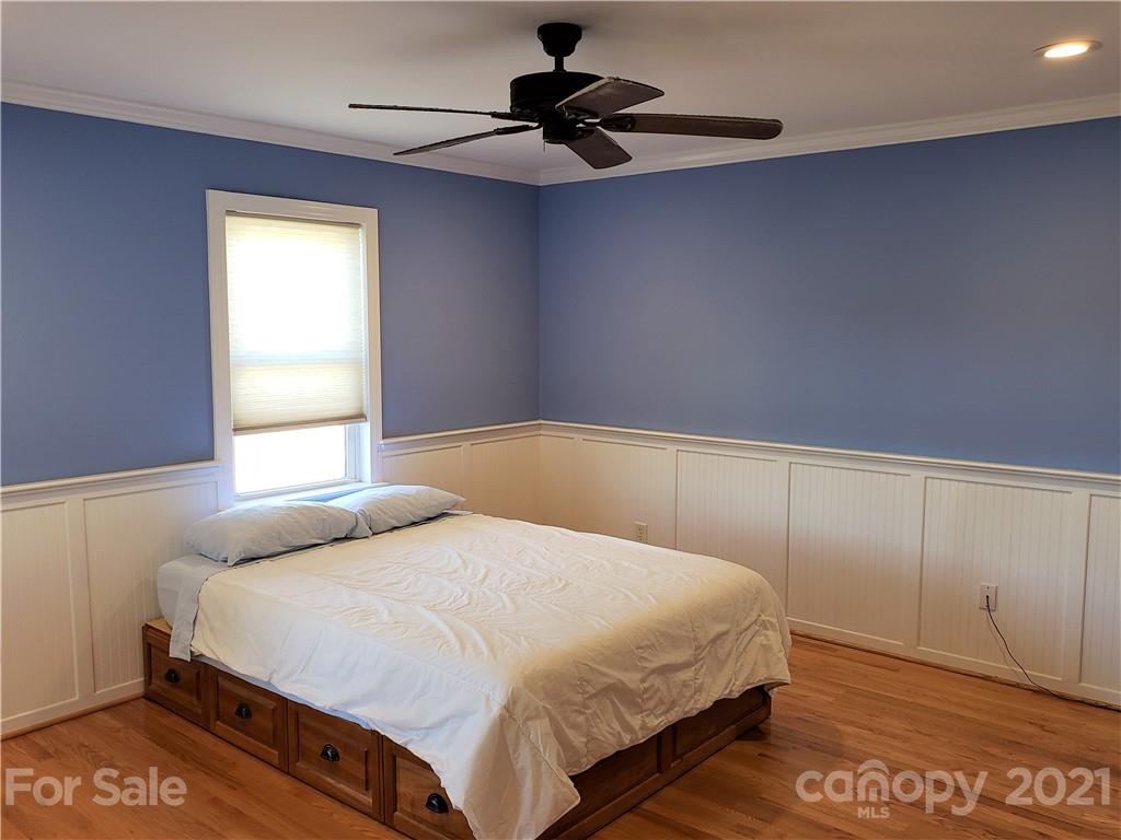 1770 Legion Road Hickory Grove, SC 29717 - Photo 38 of 48 a bedroom with a bed and a chandelier