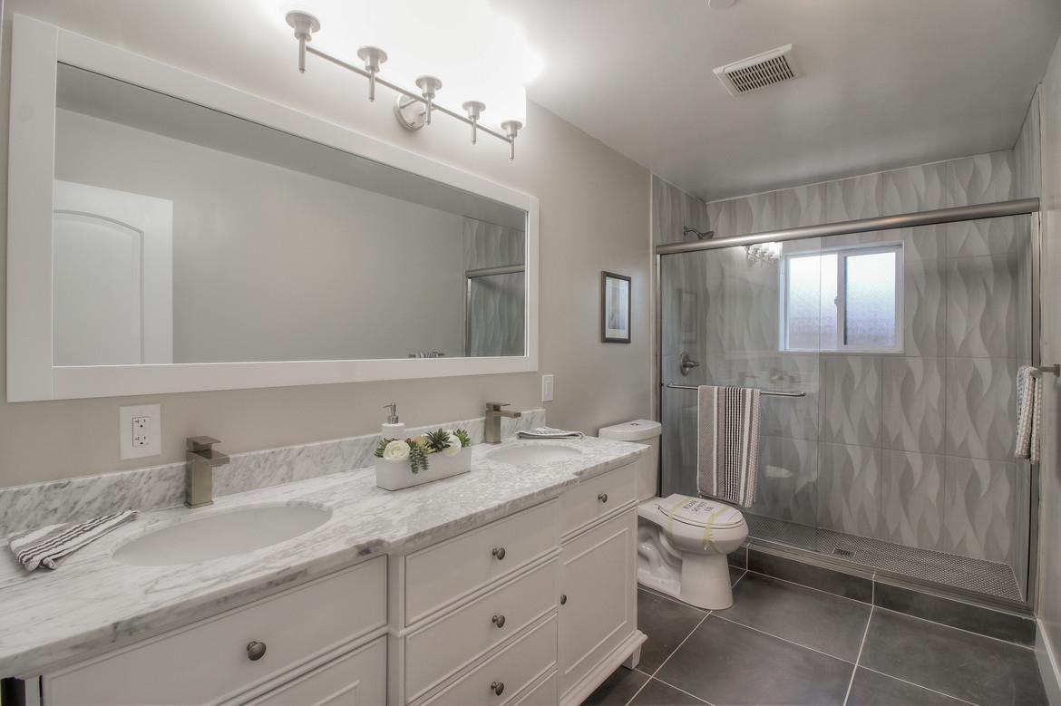856 Howe Street San Mateo, CA 94401 - Photo 24 of 32 a bathroom with a double vanity sink toilet and shower