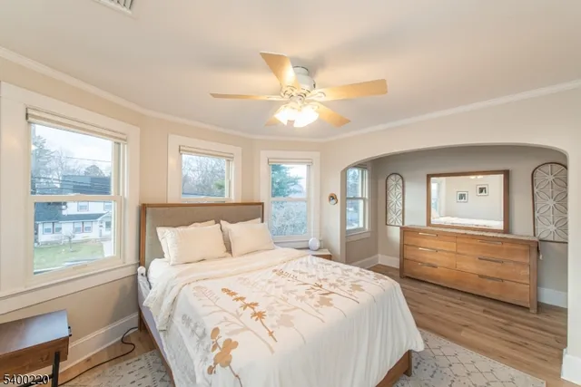 a bedroom with a large bed and a chandelier fan