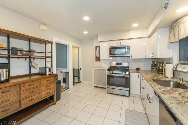 a kitchen with stainless steel appliances granite countertop a stove and a sink