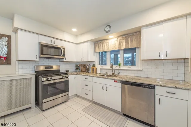 a kitchen with stainless steel appliances granite countertop a sink and cabinets
