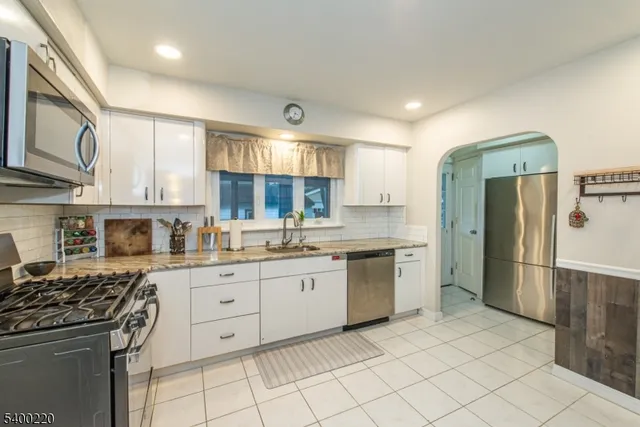 a kitchen with granite countertop cabinets stainless steel appliances and a counter space