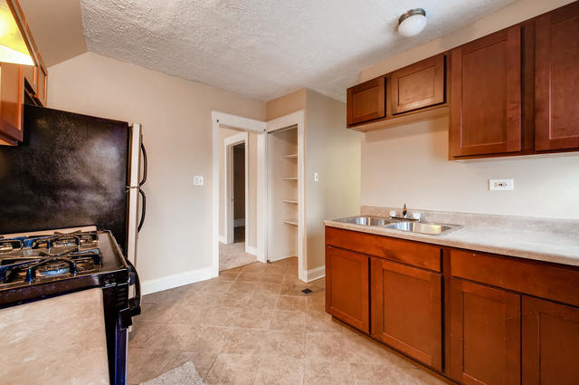 473 North Spring Street Elgin, IL 60120 - Photo 11 of 16 a kitchen with stainless steel appliances granite countertop a stove a sink dishwasher and a refrigerator with wooden cabinets