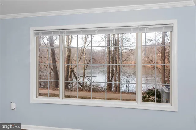 a view of a room that has a large window and wooden floor