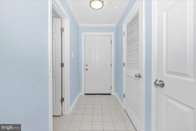 a view of a hallway with wooden floor and a bathroom