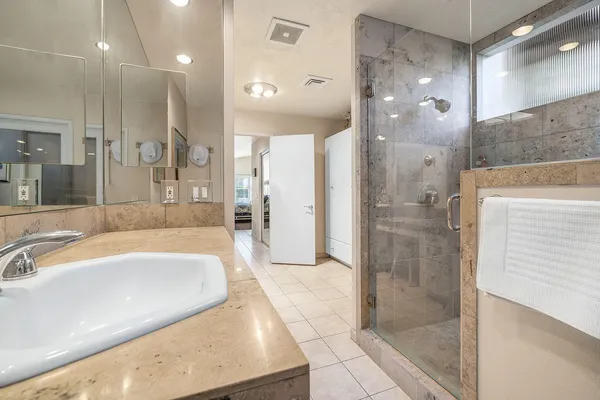 a bathroom with double vanity sinks a mirror and a shower