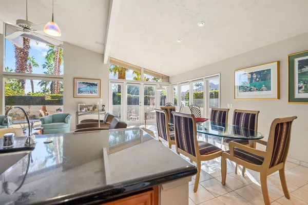 a living room with furniture a flat screen tv and kitchen view